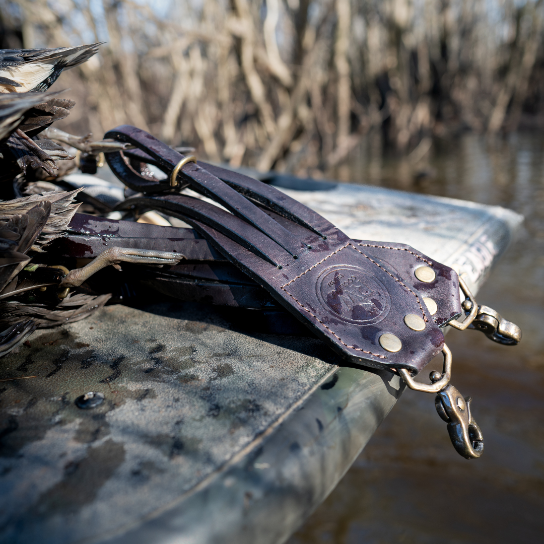 Leather Duck Strap loaded with birds resting on a boat gunwale in the marsh