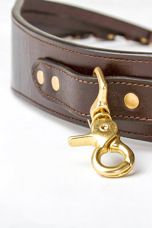 Macro detail of solid brass swivel hook and hand stitching on the Leather Duck Strap